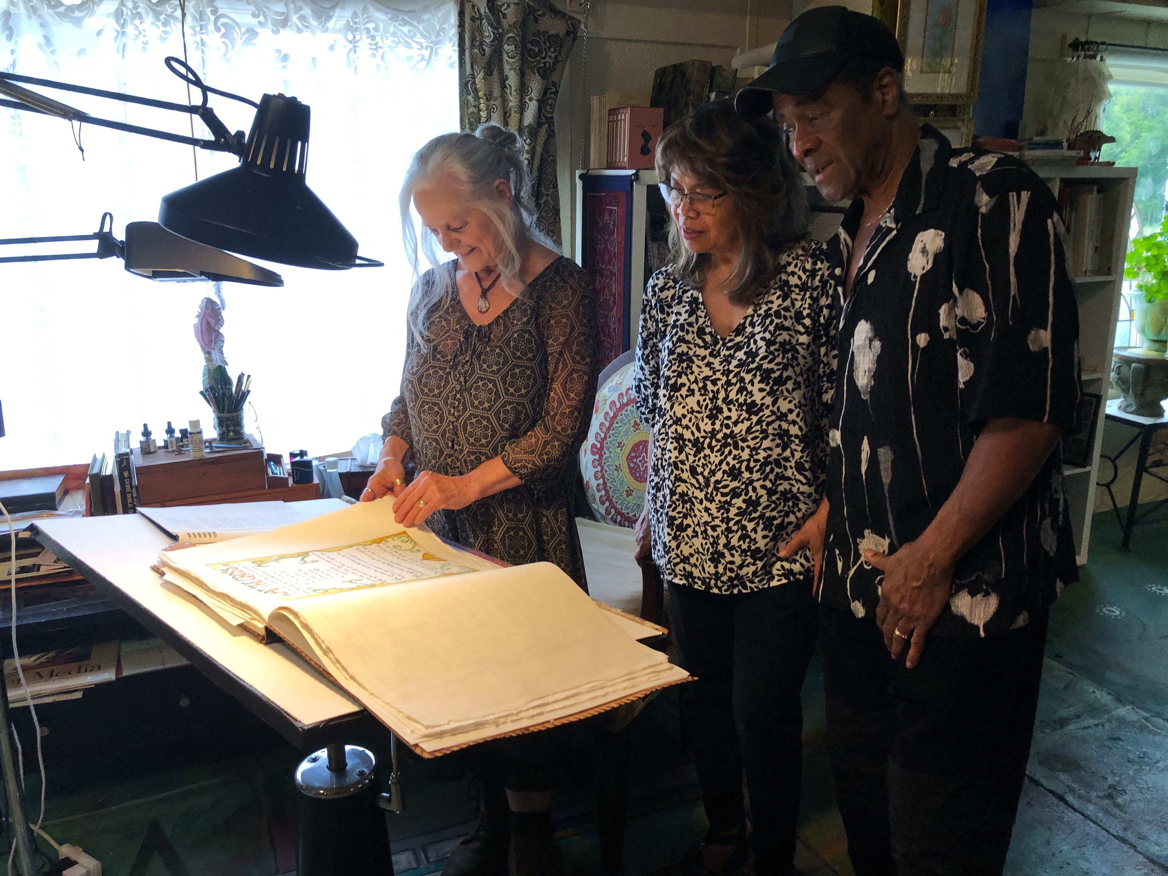Dr. debi Story Maddox reviewing her Captivating Hymns book with Leon and Renee Patillo