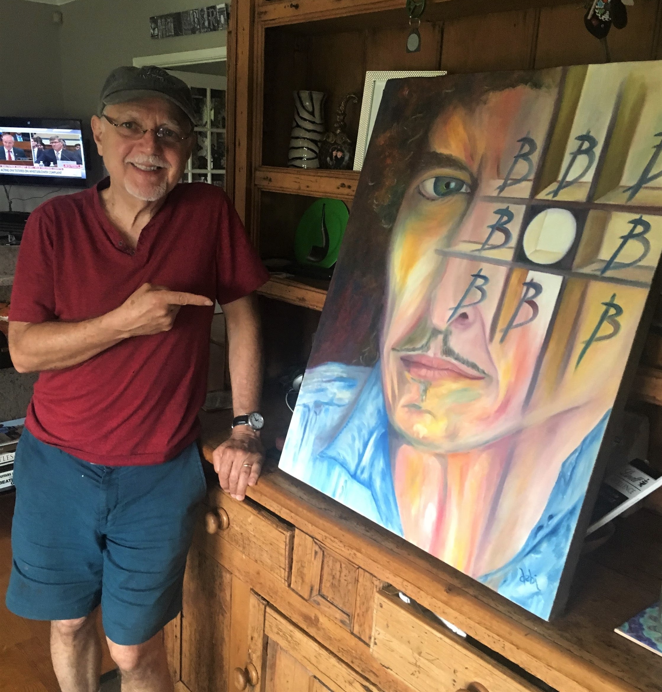 Phil Keaggy in his studio with Dr. debi Story Maddox's I Win painting of Bob Dylan